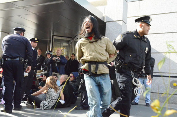 「（警察は）恥を知れ」。青年が逮捕、連行されるとデモ参加者から非難の声があがった。=３日（現地時間）、ゴールドマン・サックスが入居するビルの玄関前。写真：筆者撮影=