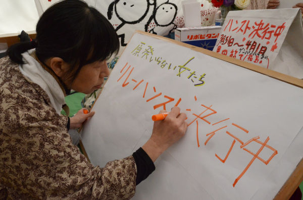 「ハンスト決行」の看板を作製しているのは、『原発いらない福島の女たち』共同代表の椎名千恵子さん。＝撮影：筆者＝