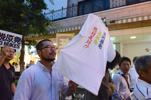 海を守るため参加した漁師は「浜岡原発再稼働、絶対反対」のTシャツを掲げて歩いた。=写真：諏訪撮影=