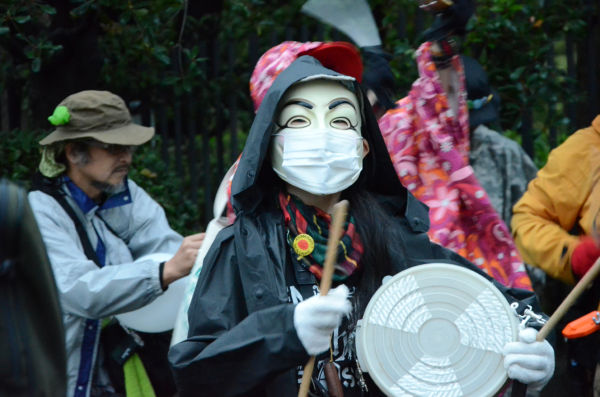 アノニマスのマスクを被った参加者。アノニマスの現れるところ独裁政権への挑戦が始まる。=写真：諏訪撮影=　
